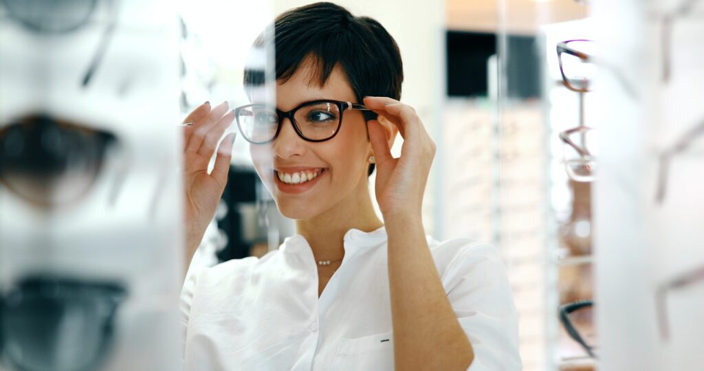 Beautiful woman with optician trying eyeglasses